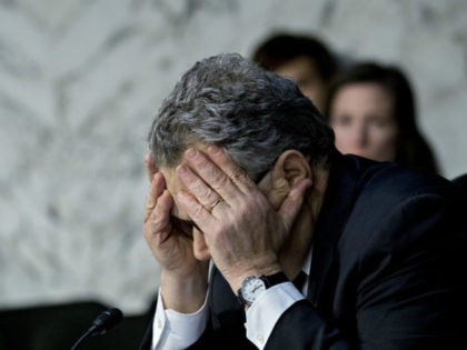 Sen. Al Franken with head down and face covered