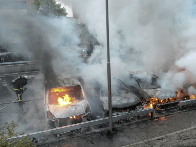 Firemen extinguish burning cars in the Stockholm suburb of Rinkeby after youths rioted in several different suburbs around Stockholm, Sweden for a fourth consecutive night on May 23, 2013. In the suburb of Husby, where the riots began on Sunday in response to the fatal police shooting of a 69-year-old …