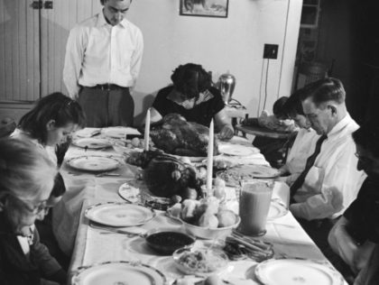 circa 1955: An American family, say grace before starting on the Thanksgiving turkey. (P