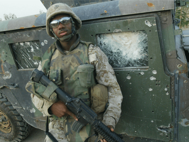 RAMADI, IRAQ: A US marine with 2/5 Marines stands in front of a Humvee hit by an Improvise