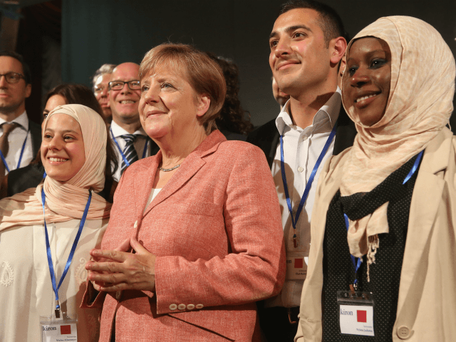 BERLIN, GERMANY - AUGUST 25: (L to R) Kiron Open Higher Education student Wafaa Almonayer, from Syria, German Chancellor Angela Merkel (CDU), Kiron Student Ehab Badwi, from Syria, and Kiron student Nyima Jadama, from Gambia, pose after a panel discussion at Kiron's offices on August 25, 2017 in Berlin, Germany. …