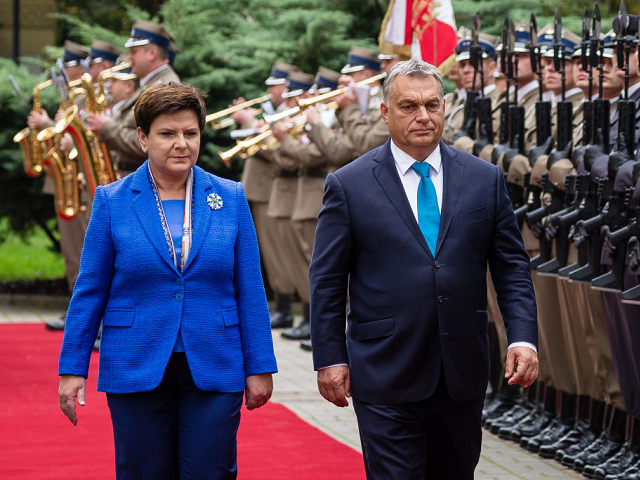 Hungarian Prime Minister Viktor Orban (R) and his Polish counterpart Beata Szydlo review t