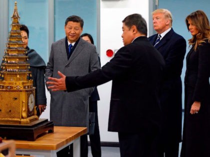 US President Donald Trump (2nd R) and First Lady Melania Trump (R) and China's President Xi Jinping (2nd L) and his wife Peng Liyuan (L partially obscured) look at an 18th century clock with lifting tower as they tour the Conservation Scientific Laboratory of the Forbidden City in Beijing on …