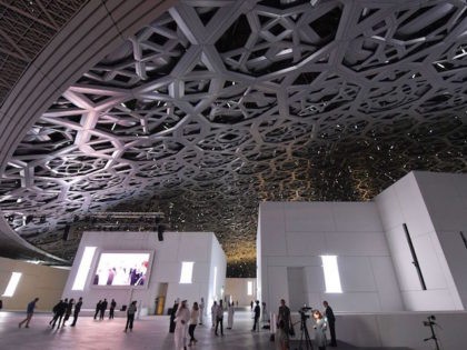 A general view shows people walking under the dome at the Louvre Abu Dhabi Museum that was designed by French architect Jean Nouvel during its inauguration on November 8, 2017 on Saadiyat island in the Emirati capital.