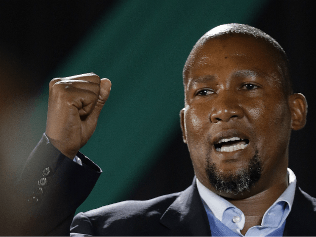 Nelson Mandela's grandson Mandla Mandela clenches his fist as he speaks during a farewell ceremony by the African National Congress at Waterkloof Air Base on the outskirts of Pretoria, South Africa, Saturday, Dec. 14, 2013. The remains of Nelson Mandela were being transferred amid pomp and ceremony to his home …