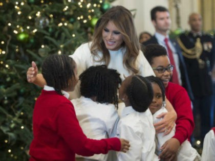 US First Lady Melania Trump hugs children in the East Room as she tours Christmas decorati