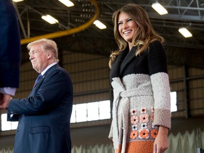 President Donald Trump, center, and first lady Melania Trump, right, take the stage at a hanger rally at Yokota Air Base, Sunday, Nov. 5, 2017, in Fussa, on the outskirts of Tokyo, Japan. (AP Photo/Andrew Harnik)