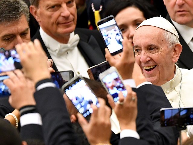 TOPSHOT - Pope Francis (R) arrives to lead his weekly general audience at Paul VI hall on December 21, 2016 at the Vatican as people take pictures of him with their cell-phone. / AFP / Alberto PIZZOLI (Photo credit should read ALBERTO PIZZOLI/AFP/Getty Images)