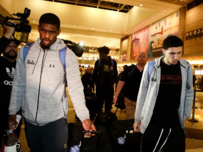UCLA basketball players Cody Riley, left, LiAngelo Ball, right, and Jalen Hill, background center, are surrounded by the media as they leave the Los Angeles International Airport on Tuesday, Nov. 14, 2017, in Los Angeles. The three UCLA basketball players detained in China on suspicion of shoplifting returned home, where …
