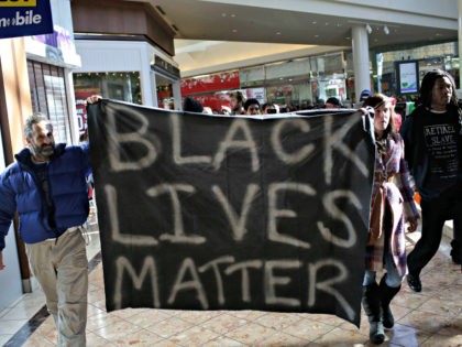 Demonstrators protesting the shooting death of Michael Brown hold a banner as they walk th