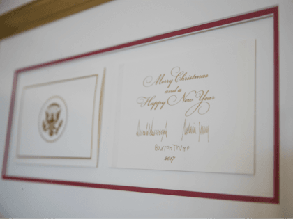 The official White House Christmas card signed by President Donald Trump, first lady Melania Trump, and their son Barron Trump is seen in the East Garden Room during a media preview of the 2017 holiday decorations at the White House in Washington, Monday, Nov. 27, 2017. (AP Photo/Carolyn Kaster)