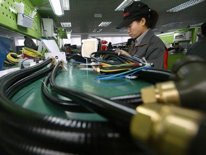 YINCHUAN, CHINA: A factory worker makes parts at a joint venture Chinese and Japanese elec