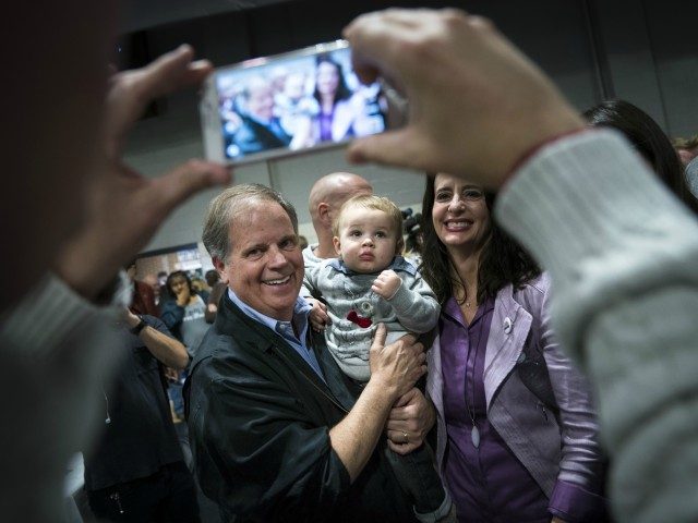 BIRMINGHAM, AL - NOVEMBER 18: Democratic candidate for U.S. Senate Doug Jones poses for a photo with a baby after speaking at a fish fry campaign event at Ensley Park, November 18, 2017 in Birmingham, Alabama. Jones has moved ahead in the polls of his Republican opponent Roy Moore, whose …