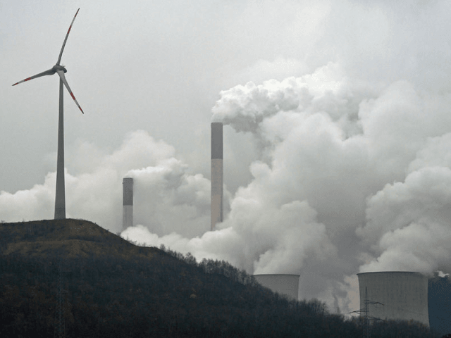 FILE - In this file photo dated Monday, Dec. 1, 2014, a wind turbine overlooks the coal-fired power station in Gelsenkirchen, Germany. A U.N.’s environment report Tuesday Oct. 31, 2017 says countries and industries need to do more to meet targets to trim emissions of greenhouse gases that experts say are contributing to global warming. In its latest “Emissions Gap” report issued ahead of an important climate conference in Germany next week, UNEP takes aim at coal-fired electricity plants being built in developing economies and says investment in renewable energies will pay for itself _ and even make money _ over the long term. (AP Photo/Martin Meissner, file)