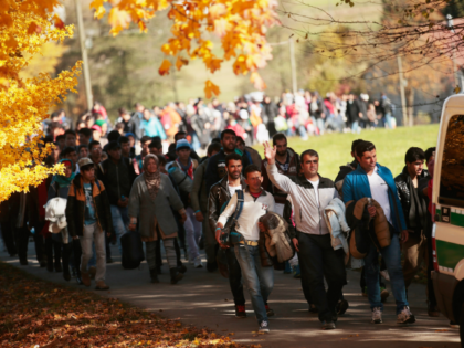 German police lead arriving migrants alongside a street to a transport facility after gathering them at the border to Austria on October 28, 2015 near Wegscheid, Germany. Bavarian Governor Horst Seehofer has accused the Austrian government of wantonly shuttling migrants in buses from the Slovenian border across Austria and dumping …