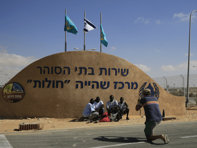 African migrants pose for a photograph in front of the Holot detention center in the Negev