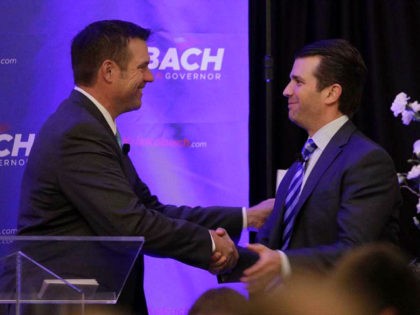 Donald Trump Jr., right, and Kansas Secretary of State Kris Kobach shake hands during a fu