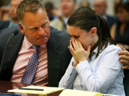 Casey Anthony, right, is comforted by Todd Macaluso, part of her defense legal team, Friday, August 21, 2009, as she cries after seeing her father George Anthony testify during a court hearing, in Orlando, Florida. (Photo by Pool photo by Red Huber/Orlando Sentinel/MCT via Getty Images)