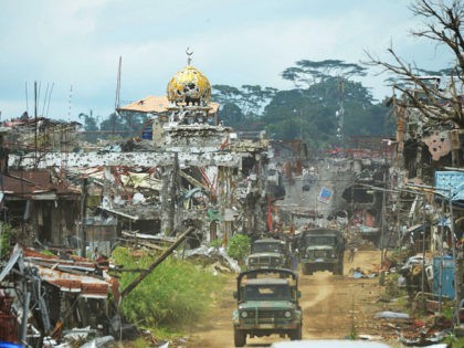 Military trucks drive past destroyed buildings and a mosque in what was the main battle area in Marawi on the southern island of Mindanao on October 25, 2017, days after the military declared the fighting against IS-inspired Muslim militants over. Philippine troops of a southern Philippine city where Islamic State …