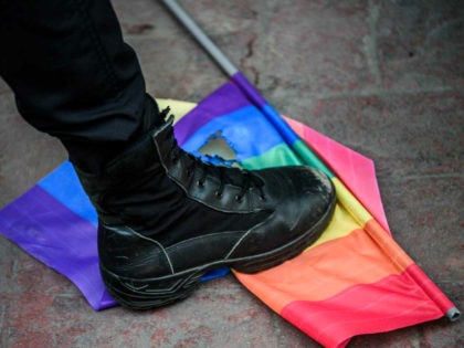 TOPSHOT - A Turkish anti-riot police officer steps on a rainbow flag during a rally staged by the LGBT community on Istiklal avenue in Istanbul on June 19, 2016. Turkish riot police fired rubber bullets and tear gas to break up a rally staged by the LGBT community in Istanbul …