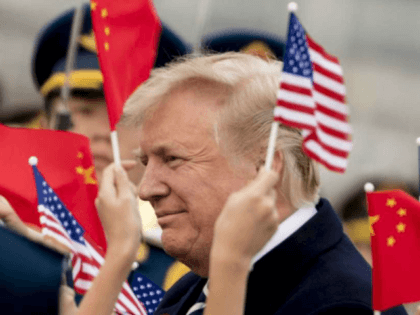 Children wave U.S. and Chinese flags as President Donald Trump arrives at Beijing Airport,