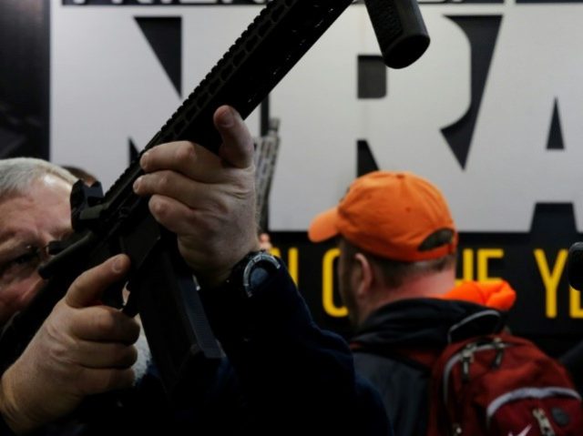 A visitor sights a rifle at a National Rifle Association outdoor sports trade show. The NR