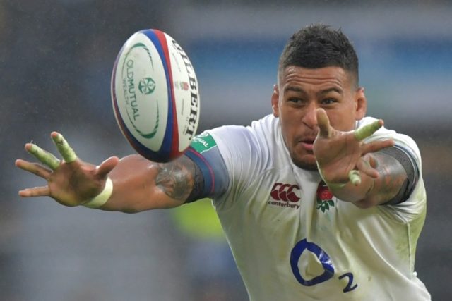 England's number 8 Nathan Hughes off-loads the ball during the international rugby union t