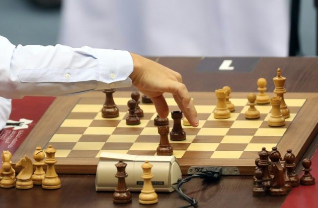 Norway's Magnus Carlsen (L) moves his rook during his game against Cuba's Leinier Domingue