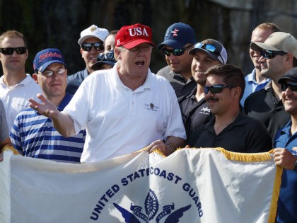 President Donald Trump speaks with members of the Coast Guard who he invited to play golf at Trump International Golf Club, Friday, Dec. 29, 2017, in West Palm Beach, Fla. (AP Photo/Evan Vucci)