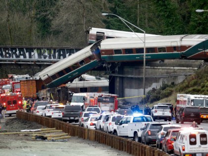 Cars from an Amtrak train lay spilled onto Interstate 5 below as some remain on the tracks above Monday, Dec. 18, 2017, in DuPont, Wash. The Amtrak train making the first-ever run along a faster new route hurtled off the overpass Monday near Tacoma and spilled some of its cars …