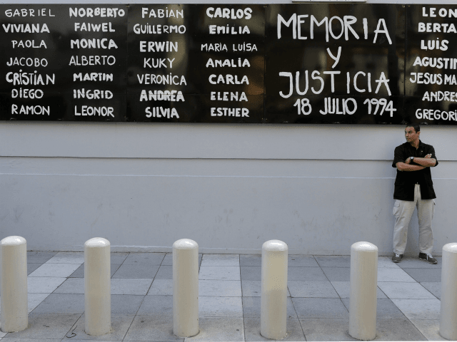 A man stands guard in front of the headquarters of AMIA (Argentine Israelite Mutual Associ