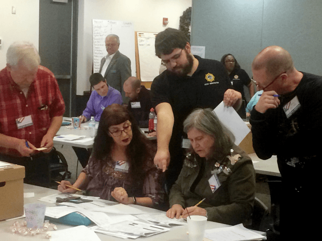 Election officials in Newport News, Va., examine ballots that a computer failed to scan du
