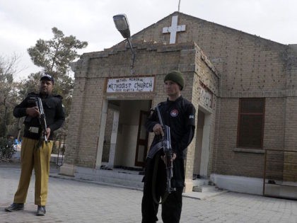 Pakistani policemen stand guard outside a church during a Christmas mass in Quetta on Dece
