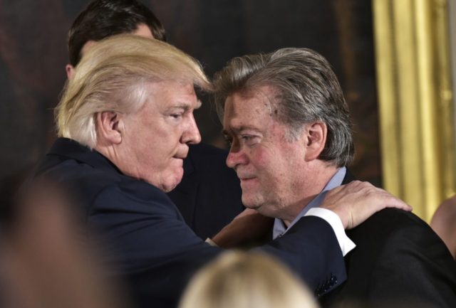 US President Donald Trump (L) congratulates Senior Counselor to the President Stephen Bannon during the swearing-in of senior staff in the East Room of the White House on January 22, 2017 in Washington, DC. / AFP / MANDEL NGAN (Photo credit should read MANDEL NGAN/AFP/Getty Images)