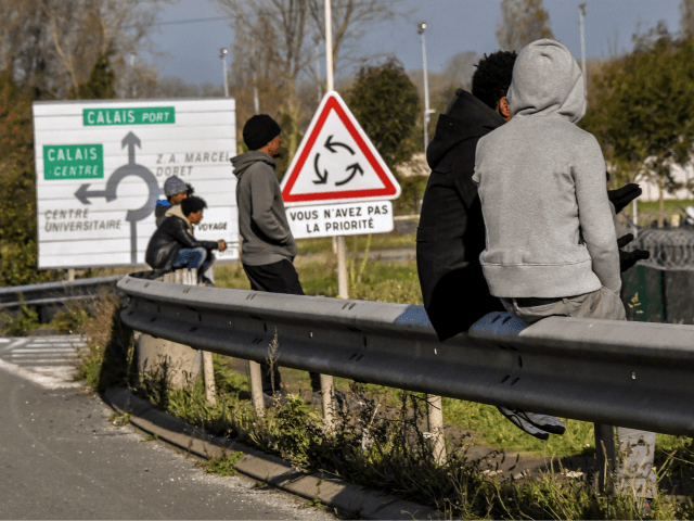 Migrants sit on the barriers along the ring road heading to the harbour of the French northern city of Calais, on November 2, 2017, next to a lorry parking lot. In Calais, local associations put the number of migrants sleeping rough around the town at around 600-700 and they have …