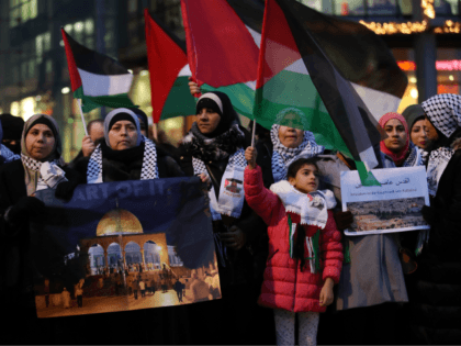 BERLIN, GERMANY - DECEMBER 12: Arabic-speaking protesters, including a woman holding a photograph of the Dome of the Rock in Jerusalem, attend a gathering to protest against the recent announcemment by U.S. President Donald Trump to recognize Jerusalem as the capital of Israel on December 12, 2017 in Berlin, Germany. …