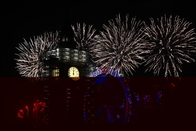LONDON, ENGLAND - JANUARY 01: Fireworks explode over Big Ben as thousands gather to ring