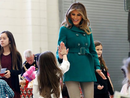 First lady Melania Trump high fives the daughter of a military family, Wednesday, Dec. 13, 2017, while sorting toys during a "Toys for Tots" event at Joint Base Anacostia-Bolling in Washington. (AP Photo/Jacquelyn Martin)