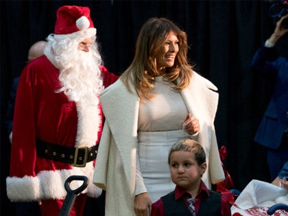 First lady Melania Trump accompanied by Santa Claus arrives to read The Polar Express to children at Children's National Medical Center, Thursday, Dec. 7, 2017, in Washington. (AP Photo/Andrew Harnik)
