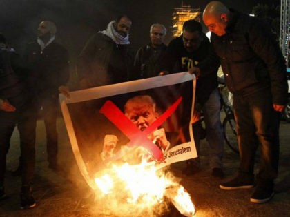 TOPSHOT - Palestinian protesters burn pictures of US President Donald Trump at the manger square in Bethlehem on December 5, 2017. US President Donald Trump told Palestinian leader Mahmud Abbas in a phone call that he intends to move the US embassy from Tel Aviv to Jerusalem, Abbas's office said. …