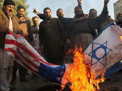 Protester burn US and Israeli flags during a protest in Multan on December 7, 2017, following US President Donald Trump's decision to officially recognise Jerusalem. / AFP PHOTO / - (Photo credit should read -/AFP/Getty Images)