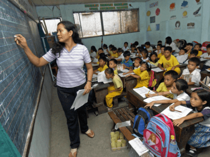 Manila, PHILIPPINES: Teacher Leonora Jusay give a lesson to her 59 students of a Grade 2 class, packed in small classroom that was a former toilet of the government-run Commonwealth Elementary School in Quezon city, suburban Manila, 07 July 2006. The dire situation in this overcrowded public school has become …