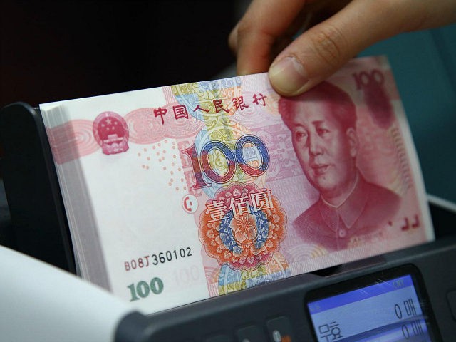 An employee puts Chinese one-hundred yuan banknotes in a money counting machine for a photograph at the Korea Exchange Bank headquarters in Seoul, South Korea, on Thursday, Feb. 27, 2014. Chinas central bank is forecast to double the yuans trading band in the coming quarter as policy makers loosen exchange-rate …