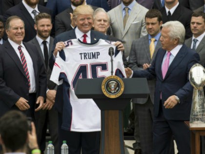 US President Donald Trump holds a jersey given to him by New England Patriots owner Robert Kraft (R) and head coach Bill Belichick (L) alongside members of the team during a ceremony honoring them as 2017 Super Bowl Champions on the South Lawn of the White House in Washington, DC, …