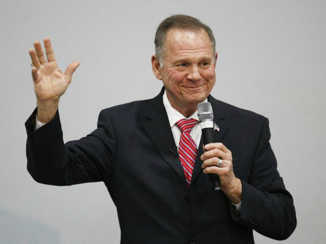 Roy Moore with hand raised and smile