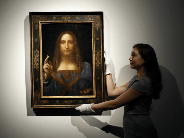 An employee poses with Leonardo da Vinci's 'Salvator Mundi' on display at Christie's aucti