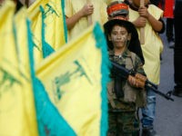 child-gun-Hezbollah-flag-ap In this Sunday, Oct. 9, 2016 photo, a child, in camouflage and with face painted holds a toy gun, during a rally to mark the seventh day of Ashoura, in the southern village of Seksakiyeh, Lebanon. Ashoura is the annual Shiite Muslim commemoration marking the death of Imam Hussein, the …