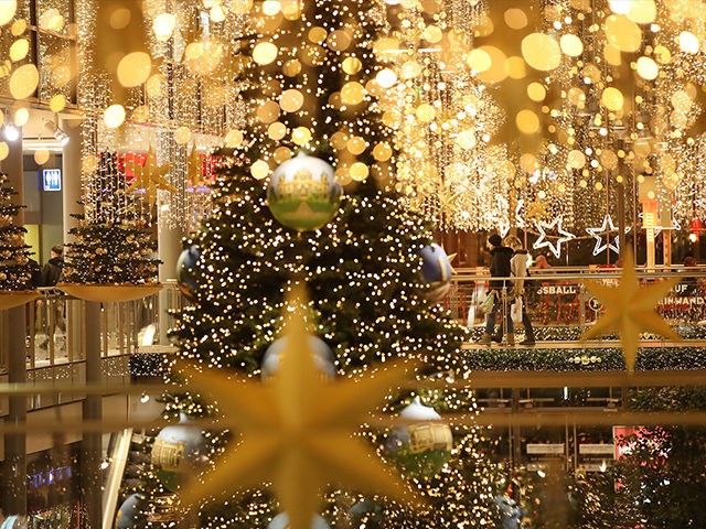 BERLIN, GERMANY - NOVEMBER 30: People walk among Christmas lights and decorations at a sho