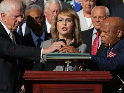 WASHINGTON, DC - OCTOBER 04: Rep. Mike Thompson (D-CA) (L) and Rep. John Lewis (D-GA) adjust the microphone for former Congresswoman and gun violence victim Gabby Giffords (C) as she addresses a rally with fellow Democrats on the East Front steps of the U.S. House of Representatives October 4, 2017 …