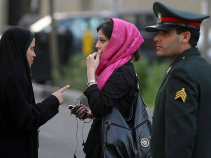 TEHRAN, IRAN - APRIL 22: An Iranian policewoman (L) warns a woman about her clothing and hair during a crackdown to enforce Islamic dress code on April 22, 2007 in Tehran, Iran. Police issued warnings and conducted arrests during an annual pre-summer crackdown, which was given greater prominence this year, …